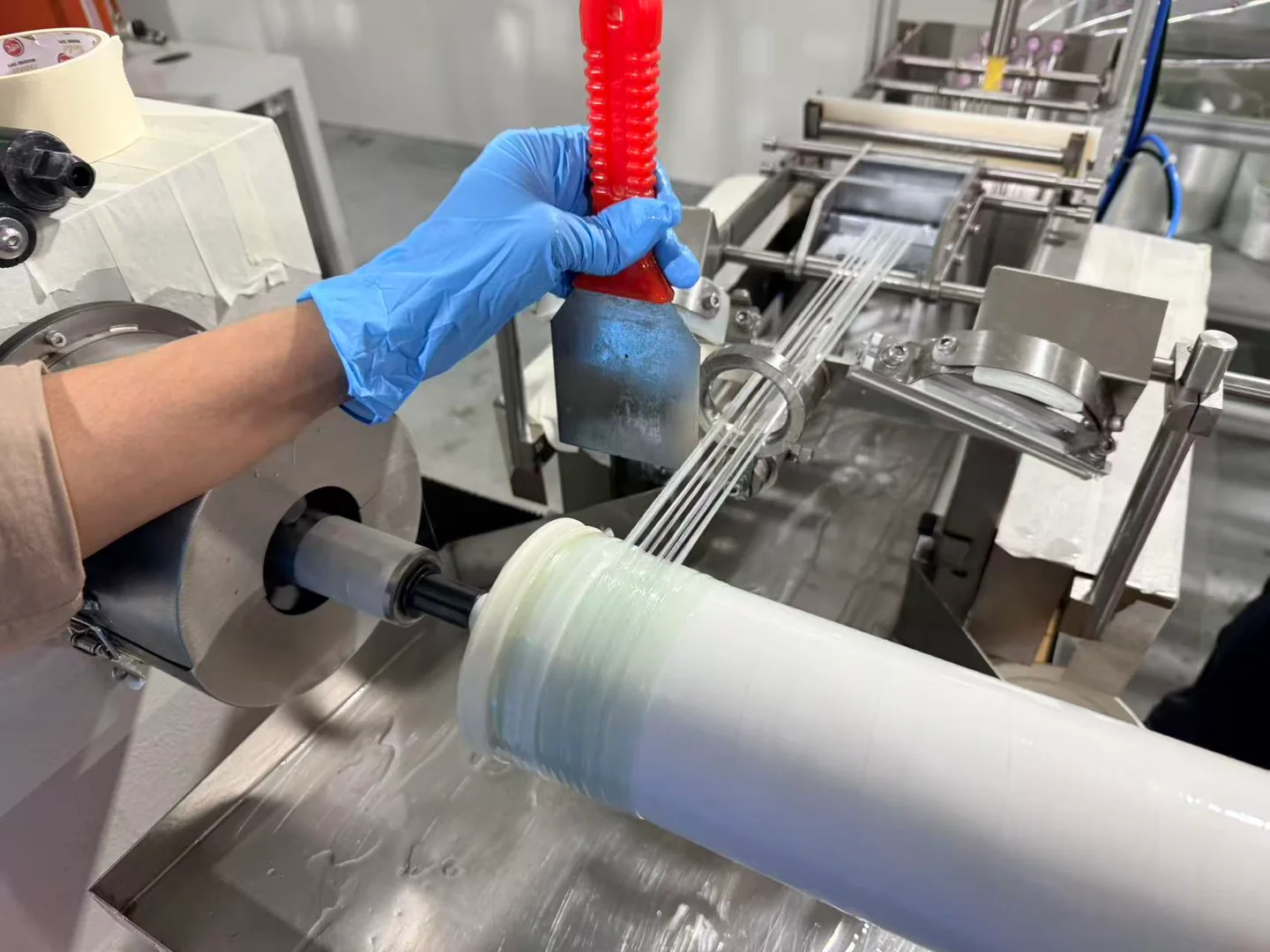Fiberglass strands feeding onto an RO membrane element at the resin-winding workstation